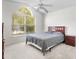 Bright bedroom featuring a large arched window, ceiling fan, and neutral carpet at 464 Dominish Estates Dr, Apopka, FL 32712