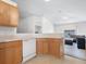 Well-lit kitchen featuring wood cabinets, white appliances, and a view into the adjacent living area at 464 Dominish Estates Dr, Apopka, FL 32712