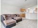 Open-concept living room featuring neutral carpet, a sectional sofa with kitchen bar in the background at 464 Dominish Estates Dr, Apopka, FL 32712