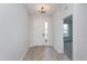 Bright entryway featuring wood-look flooring, white door with sidelight, and view into a carpeted room at 5097 Grand Teton Ct, Deland, FL 32724