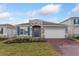 Charming one-story home featuring a brick driveway, stone accents, manicured lawn, and inviting blue front door at 5097 Grand Teton Ct, Deland, FL 32724