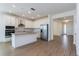 Open-concept kitchen featuring stainless steel appliances, white cabinets, an island, and wood-look flooring at 5097 Grand Teton Ct, Deland, FL 32724