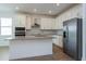 Modern kitchen featuring white cabinetry, stainless steel appliances, gray countertops, and wood-look flooring at 5097 Grand Teton Ct, Deland, FL 32724