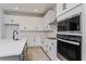 Close-up of a modern kitchen featuring white cabinets, stainless steel appliances, and modern backsplash at 5097 Grand Teton Ct, Deland, FL 32724