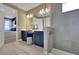 Modern bathroom featuring a double vanity with blue cabinets, a shower, and a separate toilet room at 5306 Marshelder St, Apopka, FL 32712