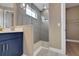 Modern bathroom featuring walk-in shower with tiled walls and blue vanity with gold hardware at 5306 Marshelder St, Apopka, FL 32712