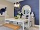 Inviting dining room featuring a modern chandelier, white table, and statement mirror on a blue accent wall at 5306 Marshelder St, Apopka, FL 32712