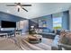 Stylish living room featuring a large blue sofa, modern decor, and ample natural light from the big window at 5306 Marshelder St, Apopka, FL 32712