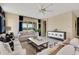 Bright living room with contemporary furnishings, neutral color palette, ceiling fan, and sliding glass doors to the exterior at 5306 Marshelder St, Apopka, FL 32712