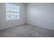 Cozy bedroom featuring a bright window, plush carpet, and neutral walls at 5391 Dragonfly Dr, Wildwood, FL 34785