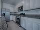 Updated kitchen with white cabinets, stainless steel refrigerator, and built-in microwave at 5391 Dragonfly Dr, Wildwood, FL 34785