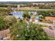 An aerial view of a home with a pond nearby and a clear view of neighborhood at 5428 Tangelo St, Leesburg, FL 34748