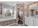 Well-lit bathroom features dual sink vanity, soaking tub under window, and tiled floors at 5428 Tangelo St, Leesburg, FL 34748