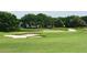 Golf course view with green grass, sand traps, and a pond offering beauty and recreation at 5428 Tangelo St, Leesburg, FL 34748