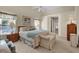 Bright main bedroom features a ceiling fan, sitting bench, and access to the ensuite bathroom at 5428 Tangelo St, Leesburg, FL 34748