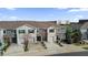 View of a gray townhome with a driveway and a garage, complemented by the well-maintained lawns and trees at 5435 Dragonfly Dr, Wildwood, FL 34785