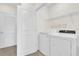 Convenient laundry room with modern washer and dryer, shelving and white walls at 5435 Dragonfly Dr, Wildwood, FL 34785