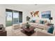 Bright living room with a tan sofa set, coffee table, area rug and sliding glass doors to the patio at 5435 Dragonfly Dr, Wildwood, FL 34785