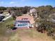 Aerial view of home with a screened in pool, surrounded by mature trees and well-maintained lawn at 5746 Crestview Dr, Lady Lake, FL 32159