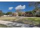 Spacious single-story home with a circular driveway and well-manicured lawn, surrounded by mature trees at 5746 Crestview Dr, Lady Lake, FL 32159