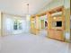 Open-concept living room featuring a chandelier, built-in shelving and lush views from the large window at 5746 Crestview Dr, Lady Lake, FL 32159