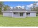 Backyard view of a single-Gathering home featuring a lawn and covered patio at 68 Malauka Pass Crse, Ocklawaha, FL 32179