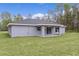 Rear exterior view of a single Gathering home with a covered patio and green lawn at 68 Malauka Pass Crse, Ocklawaha, FL 32179