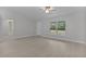 A well-lit living room with plank flooring, a ceiling fan, and a large window offering views of the outdoors at 68 Malauka Pass Crse, Ocklawaha, FL 32179