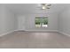 A bright living room features sleek plank flooring, a neutral color scheme, and a large window at 68 Malauka Pass Crse, Ocklawaha, FL 32179