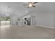 An open-concept living space with plank flooring, flowing into a kitchen with stainless steel appliances and a breakfast bar at 68 Malauka Pass Crse, Ocklawaha, FL 32179