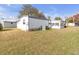 Spacious backyard showing the home's exterior, central AC unit, and partial screen porch at 730 Royal Palm Ave, The Villages, FL 32159