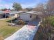 Charming single-story home featuring a covered driveway with a compass design, American flag, and well-maintained landscaping at 730 Royal Palm Ave, The Villages, FL 32159