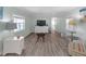 Spacious living room featuring wood-look flooring, neutral paint, natural light, and stylish furniture at 730 Royal Palm Ave, The Villages, FL 32159