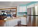 View of the kitchen adjacent to the living room with stainless steel refrigerator at 8 Gallinule Ct, Fruitland Park, FL 34731