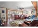 Inviting living room featuring a cozy red leather sofa, ceiling fan, and hardwood floors at 8 Gallinule Ct, Fruitland Park, FL 34731