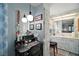 Charming main bathroom featuring light blue walls, pedestal sink, desk, and vanity area at 8 Gallinule Ct, Fruitland Park, FL 34731