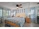 Cozy main bedroom features light blue walls, ceiling fan, window with curtains, and hardwood floors at 8 Gallinule Ct, Fruitland Park, FL 34731