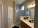 Modern bathroom with a glass-enclosed shower, marble countertops, and wood vanity at 8004 Saint Andrews Way, Mount Dora, FL 32757