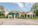 Clubhouse entrance featuring a covered portico, lush landscaping, and ample parking for the convenience of members and guests at 8004 Saint Andrews Way, Mount Dora, FL 32757