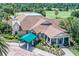 Aerial shot of clubhouse featuring a green covered portico, and lush landscaping at 8004 Saint Andrews Way, Mount Dora, FL 32757