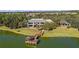 Aerial view of community center on a lake with a fishing dock, lush landscaping and mature trees at 8660 Se 132Nd Ln, Summerfield, FL 34491