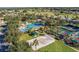 Aerial view of a community pool, tennis and shuffleboard courts, and a sand volleyball court at 8660 Se 132Nd Ln, Summerfield, FL 34491