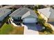 An aerial view shows a well-maintained home with a two-car garage, landscaped yard, and a paved driveway at 8660 Se 132Nd Ln, Summerfield, FL 34491