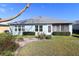 Backyard exterior showing manicured lawn, mature landscaping, and patio at 8660 Se 132Nd Ln, Summerfield, FL 34491