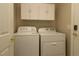 Functional laundry area with a washer, dryer, and overhead cabinets for storage at 8660 Se 132Nd Ln, Summerfield, FL 34491