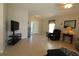 Open living room with neutral tile flooring, comfortable seating, and a view of the front entryway at 8660 Se 132Nd Ln, Summerfield, FL 34491