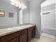 Bathroom featuring double sinks, a large mirror and a combined shower and tub at 887 Daisy Hill Ct, Apopka, FL 32712