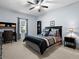 Bedroom featuring a large bed with black comforter, carpeted floors, and a dark wood desk at 887 Daisy Hill Ct, Apopka, FL 32712