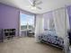 Bright bedroom with lilac walls, a canopy bed and a desk by a window with scenic views at 887 Daisy Hill Ct, Apopka, FL 32712