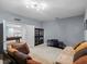 Cozy bonus room with a large sectional sofa, carpeting, and adjacent game room at 887 Daisy Hill Ct, Apopka, FL 32712